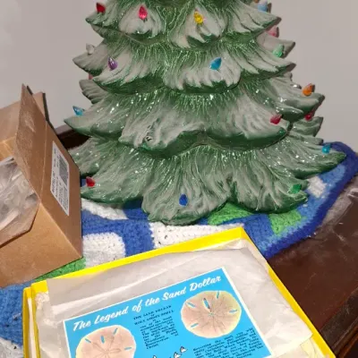 Vintage illuminated ceramic Christmas tree with colorful plastic bulbs, sitting next to a boxed "Legend of the Sand Dollar"...