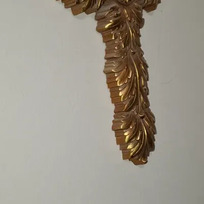 Sale Photo Thumbnail #120: Ornate gold-finished carved wall cross featuring acanthus leaf details and a central medallion.