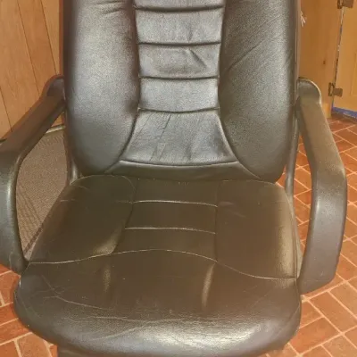 Black faux leather high-back executive office chair with a five-star caster base.