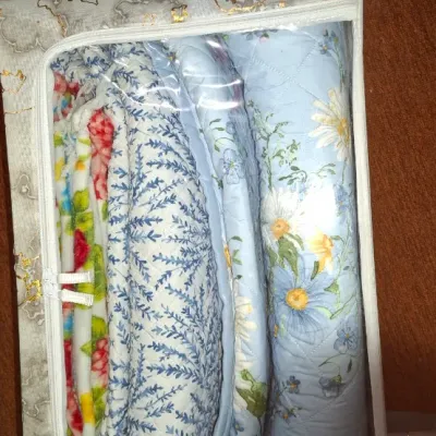 Sale Photo Thumbnail #150: Zippered fabric and clear vinyl storage bag filled with folded floral and patterned quilts.