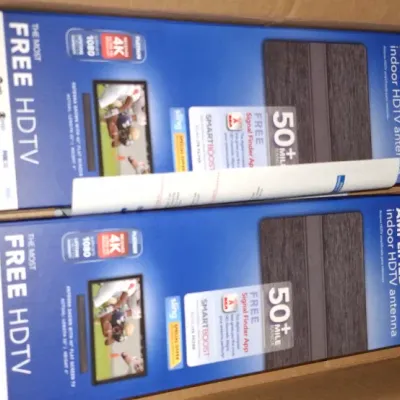 Two RCA amplified indoor HDTV antennas in original packaging, resting inside a cardboard shipping box.