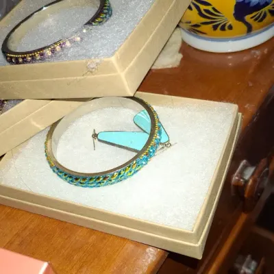 Sale Photo Thumbnail #142: Selection of costume jewelry in cardboard gift boxes, including embellished bangle bracelets and turquoise-toned dangle earrings.