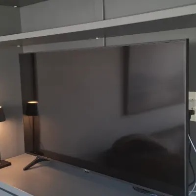Sale Photo Thumbnail #11: Modern flat-screen television situated inside a gray built-in entertainment center alongside a small cordless accent lamp.