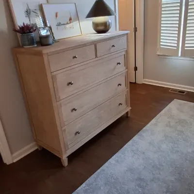 Sale Photo Thumbnail #43: Modern light wood five-drawer chest of drawers styled with a table lamp and framed wall art.