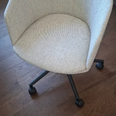 Sale Photo Thumbnail #12: Modern tub-style desk chair upholstered in light beige textured fabric, supported by a black metal four-star base on casters.