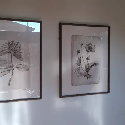 Sale Photo Thumbnail #7: Pair of large framed monochrome botanical prints featuring detailed illustrations of flowers, set in dark wooden frames under glass.
