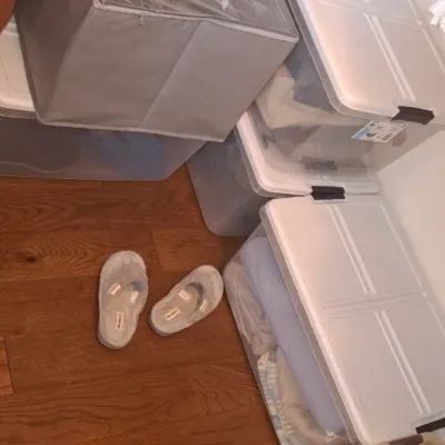 Sale Photo Thumbnail #60: Collection of plastic under-bed storage totes and a grey fabric organizer cube sitting inside a closet.
