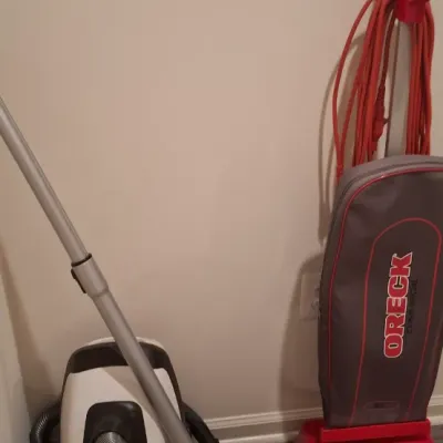 Sale Photo Thumbnail #69: Pair of modern vacuum cleaners, including a white and black Sonic Clean canister vacuum and a red Oreck XL Commercial upright vacuum.