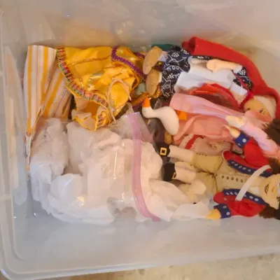 Sale Photo Thumbnail #68: Clear plastic storage tote filled with assorted vintage dolls and doll clothing.