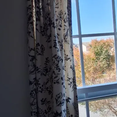 Sale Photo Thumbnail #50: Set of black and cream floral toile patterned window curtains hanging beside a grid window.