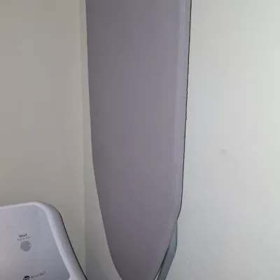 Sale Photo Thumbnail #81: Compact hanging ironing board with grey fabric cover, shown stored on a wire shelf rack above a washing machine.