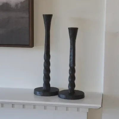 Sale Photo Thumbnail #17: Pair of modern black twist-stem candlesticks displayed on a white fireplace mantel.