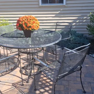 Sale Photo Thumbnail #63: Vintage wrought iron mesh patio dining set featuring a round table and four matching armchairs.