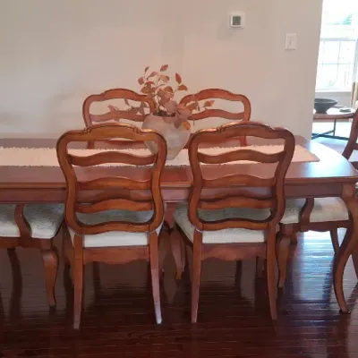 Sale Photo Thumbnail #27: French Country style dining set featuring a wooden rectangular table with cabriole legs and six matching ladder-back chairs with upholstered seats.