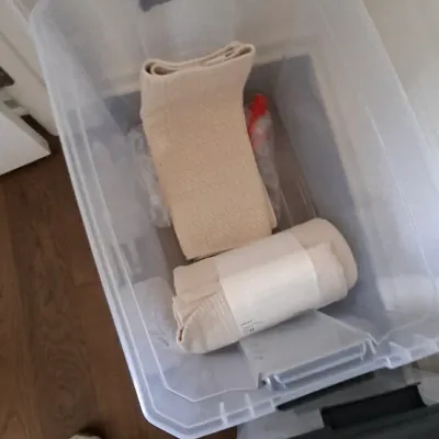 Sale Photo Thumbnail #45: Large clear plastic storage bin with grey latch handles, containing folded neutral-toned bath linens.