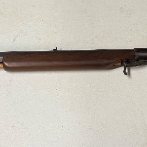 Sale Photo Thumbnail #15: Vintage black powder muzzleloader rifle featuring an octagonal barrel, wooden stock, and attached ramrod.