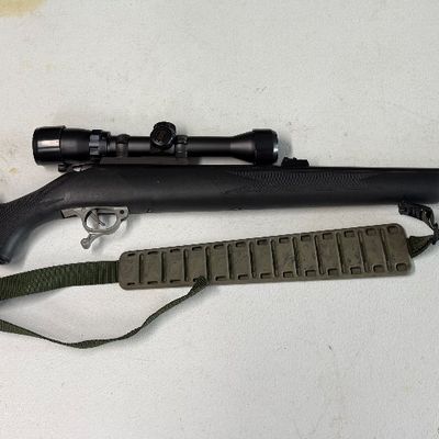 Sale Photo Thumbnail #36: Black synthetic stock muzzleloader rifle equipped with an attached optic scope and a green padded sling.