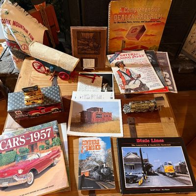 Sale Photo Thumbnail #108: Collection of vintage transportation collectibles, including railway and classic car books, a mini covered wagon, a Saturday Evening Post magazine, and novelty decorative items.