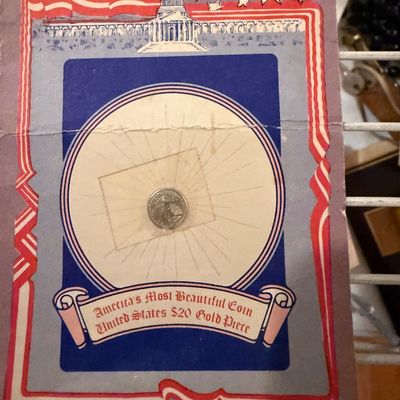Sale Photo Thumbnail #126: Novelty miniature United States $20 gold piece coin displayed on a vintage patriotic-themed card featuring the U.S. Capitol building and star borders.