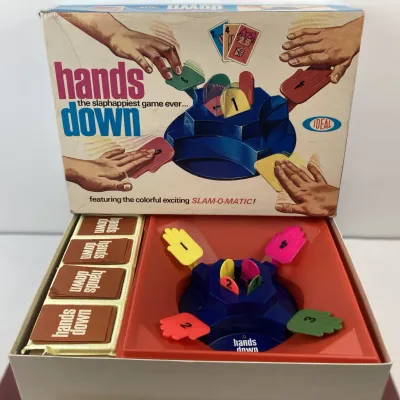 Sale Photo Thumbnail #184: Vintage 1964 Hands Down board game by Ideal, featuring the Slam-O-Matic center unit, plastic hand paddles, game cards, and original box showing light edge wear.