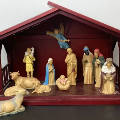 Sale Photo Thumbnail #203: Multi-piece nativity set with painted resin figurines, including Mary, Joseph, baby Jesus, the Three Wise Men, a shepherd, angel, and animals, housed in a reddish-brown wooden creche.