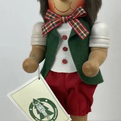 Sale Photo Thumbnail #204: Vintage handmade German wooden nutcracker figure featuring a Pinocchio-style character with a pointed red hat, green vest, plaid bowtie, and original tag.