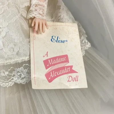 Sale Photo Thumbnail #127: Vintage Madame Alexander 'Elise' bride doll featuring an intricate lace gown and original wrist tag.