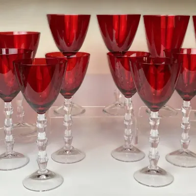 Sale Photo Thumbnail #40: Set of vintage ruby red glass stemware with clear faceted stems, including water goblets and wine glasses, displayed in excellent condition.