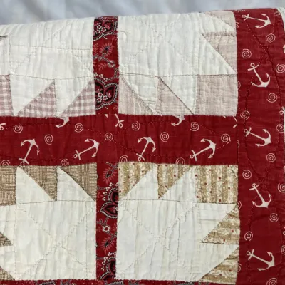 Sale Photo Thumbnail #173: Vintage patchwork quilt featuring bear paw star blocks, red anchor print sashing, and paisley accent strips.