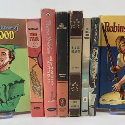 Sale Photo Thumbnail #193: Collection of vintage mid-century children's classic hardback books, featuring titles like Robin Hood, Robinson Crusoe, and Trixie Belden by Whitman and other publishers, showing light shelf wear.