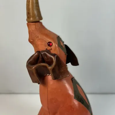 Sale Photo Thumbnail #64: Vintage leather-wrapped elephant liquor decanter with a trunk stopper and red rhinestone eyes, mid-20th century.