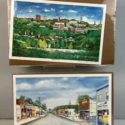 Sale Photo Thumbnail #100: Two shrink-wrapped, signed landscape prints by artist Oscar Velasquez depicting South Carolina towns Greenwood and Clemson.
