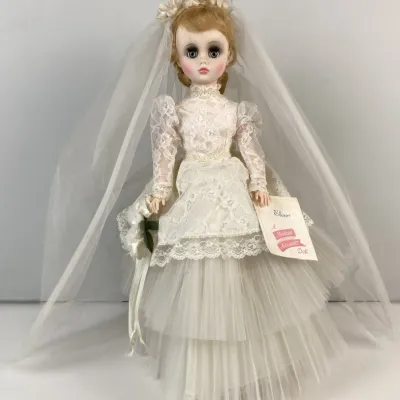 Sale Photo Thumbnail #126: Vintage Madame Alexander 'Elise' bride doll featuring a layered lace and tulle gown, veil, floral bouquet, and original hang tag.