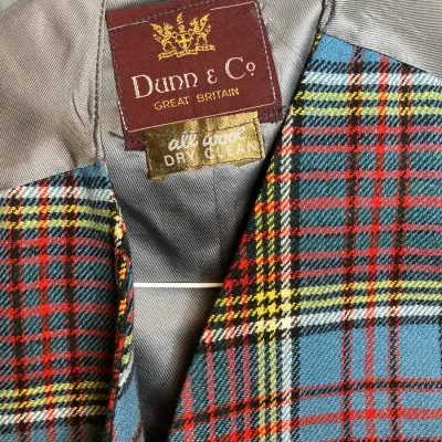 Sale Photo Thumbnail #161: Vintage Dunn & Co. Great Britain all-wool plaid vest featuring a blue, red, and yellow tartan pattern and grey lining.