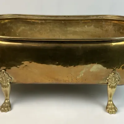 Sale Photo Thumbnail #69: Vintage brass planter shaped like a clawfoot bathtub, featuring ornate feet and side handles.