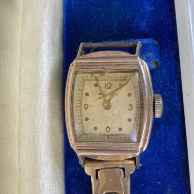Sale Photo Thumbnail #242: Vintage Kelton square-faced wristwatch with a flexible metal band, presented in a blue velvet-lined box.