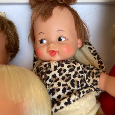 Sale Photo Thumbnail #137: Vintage Ideal Pebbles Flintstone doll wearing a leopard-print top, featuring molded vinyl face with auburn hair and side-glancing eyes.