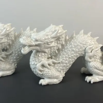 Sale Photo Thumbnail #10: Pair of white glazed porcelain Chinese dragon figurines featuring detailed scales and serpentine bodies in excellent condition.