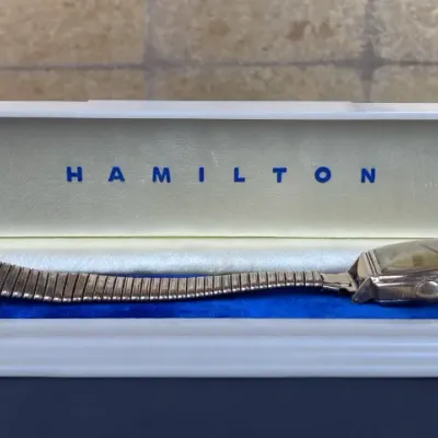Sale Photo Thumbnail #241: Vintage Hamilton men's wristwatch with a stretch expansion band, presented in its original satin and velvet lined display box.