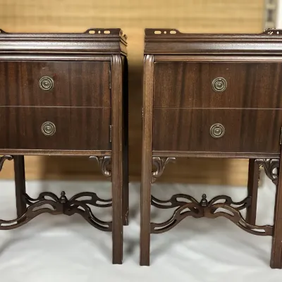 Sale Photo Thumbnail #71: Pair of vintage mahogany two-drawer nightstands featuring decorative carved aprons, brass ring hardware, and curved cross-stretchers.