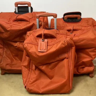 Sale Photo Thumbnail #218: Set of three orange Lipault Paris softside rolling suitcases featuring telescopic handles and matching leather trim.