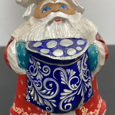 Sale Photo Thumbnail #209: Hand-carved and hand-painted wooden Russian Santa figurine featuring intricate blue and silver floral patterns on his coat and sack.