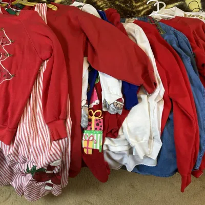 Sale Photo Thumbnail #153: Collection of vintage holiday apparel and sweaters, featuring a red embroidered Christmas tree sweatshirt and striped dress, circa 1980s-1990s.