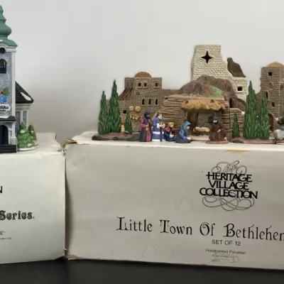 Sale Photo Thumbnail #202: Department 56 Heritage Village Collection pieces, including the Alpine Village Series 'St. Nikolaus Kirche' building and the Little Town of Bethlehem 12-piece set, both displayed with original boxes.