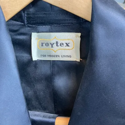 Sale Photo Thumbnail #158: Vintage Roytex black satin robe or smoking jacket hanging on a Fred Smith Co. wooden hanger.