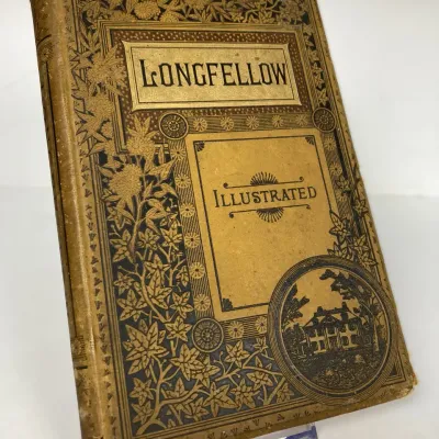 Sale Photo Thumbnail #94: Antique hardcover edition of "Longfellow Illustrated," featuring an ornate Victorian cloth binding with gilt and black embossed floral details.