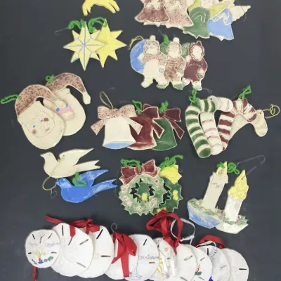 Sale Photo Thumbnail #207: Collection of handmade ceramic and painted sand dollar Christmas ornaments featuring holiday motifs including angels, Santas, stars, and bells.