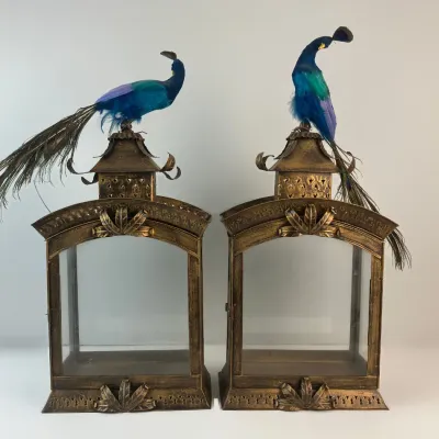 Sale Photo Thumbnail #3: Pair of ornate bronze-finished metal glass lanterns, topped with blue faux peacock figures featuring natural tail feathers.