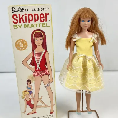 Sale Photo Thumbnail #111: Vintage 1960s Mattel Barbie's Little Sister Skipper doll with red hair, dressed in a yellow lace-trimmed party dress and shown next to her original box.