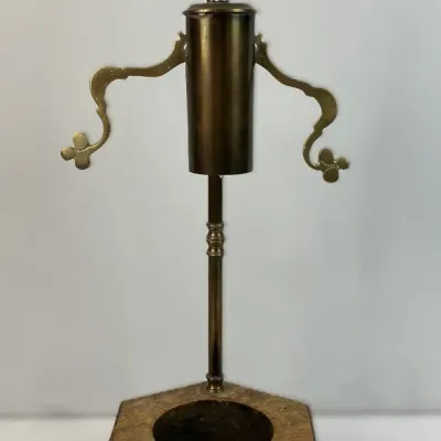 Sale Photo Thumbnail #66: Vintage brass oil lamp stand or caddy set into a hexagonal wooden base, featuring decorative scrollwork side arms and a top finial.